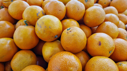 Oranges for sale in a supermarket. Citrus fruits, close-up with selective focus. Oranges in a store. Ripe, juicy, bright orange fruits. Fruits enriched with vitamin C