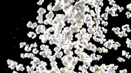 Popcorn explosion in slow motion. Fluffy white kernels bursting against black background. Close-up of popping corn. Cinematic food imagery for movie night or snack time - Powered by Adobe