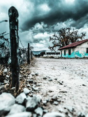 Obraz premium Abandoned House with Dramatic Sky and Rocky Pathway at Dusk