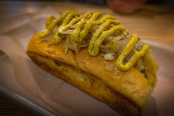 Brat with mustard and sauerkraut on hotdog roll