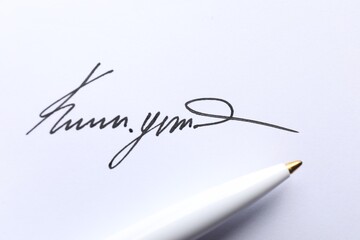 Pen and signature on white paper, closeup
