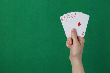 Woman with playing cards against green background, closeup. Space for text