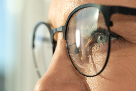 Woman wearing stylish glasses on blurred background, closeup