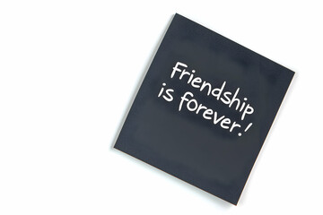 A black sticky note with the quote "Friendship is forever." isolated on the white background
