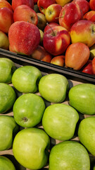 Apples for sale in a supermarket. Green and red apples close-up with selective focus. Fruits. A pile of apples for sale in a store. A variety of fresh apples on a supermarket counter