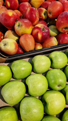 Apples for sale in a supermarket. Green and red apples close-up with selective focus. Fruits. A pile of apples for sale in a store. A variety of fresh apples on a supermarket counter