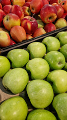 Apples for sale in a supermarket. Green and red apples close-up with selective focus. Fruits. A pile of apples for sale in a store. A variety of fresh apples on a supermarket counter