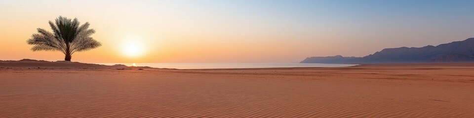 Fototapeta premium A tree is in the foreground of a desert landscape. The sun is setting in the background, casting a warm glow over the scene. The sky is a mix of orange and blue hues, creating a serene