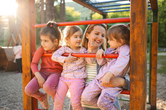 Smiling mom with daughters on the playground