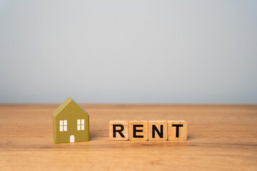 Real estate, apartment and housing rental concept. Miniature house and wooden blocks with inscription Rent