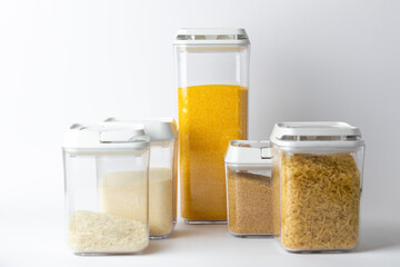 on white there are different sized transparent containers with white lids filled with different cereals with rice semolina brown sugar corn grits