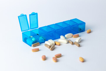 white background two bright blue pill boxes with a couple of open lids for taking pills, health...