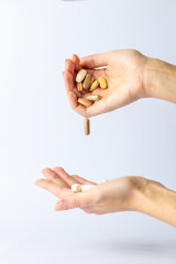 white background on outstretched palms of women hands, pills and vitamins of different shapes and colors are transferred from hand to palm suicidal thoughts depression health care, pills in the air