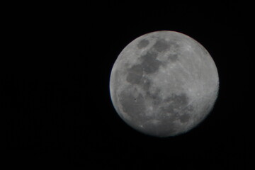 A detailed close-up of the moon against a dark night sky, showcasing its craters and surface...
