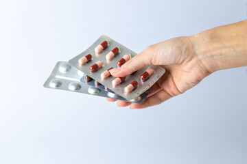 on white background on an outstretched female hand a silver blisters with colored capsules suicidal thoughts depression health care pills in the air medical care