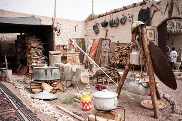 Traditional Saudi Arabian outdoor setting with rustic cookware, firewood, and cultural artifacts. A glimpse into historical Bedouin life, ideal for heritage storytelling, Saudi Founding Day, and backg