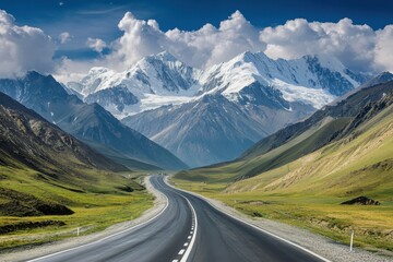 Fototapeta premium Scenic highway leading through majestic mountains under a bright blue sky