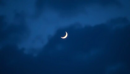 Obraz premium A crescent moon shines brightly in the evening sky