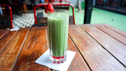 A glass of matcha, garnished with strawberry