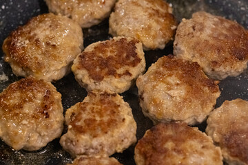 Homemade juicy meat patties frying in a pan with sizzling oil, golden brown crust, and tender texture. Traditional home cooking, comfort food, delicious meal preparation and homemade cuisine