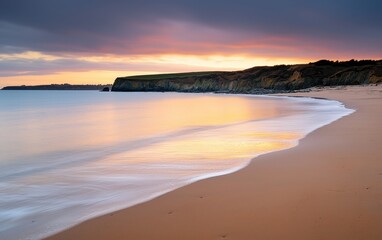 Fototapeta premium A serene beach at sunset, with gentle waves lapping against the shore and a colorful sky reflecting on the water.