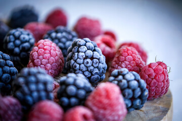 Macro of frozen raspberries and blueberries, cold berries