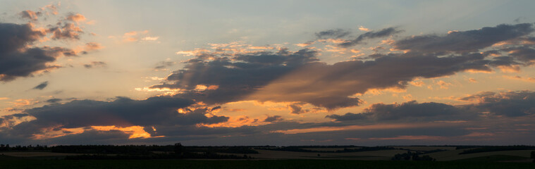 Landscape at sunset. Tragic gloomy sky. Panorama. Crimson twilight. Heavy, gloomy, dark clouds.
