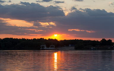 Naklejka premium A bloody sunset on the Danube River. The reflection of the landscape in the water.