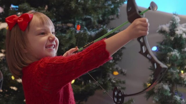 Little Girl Shooting a Toy Bow