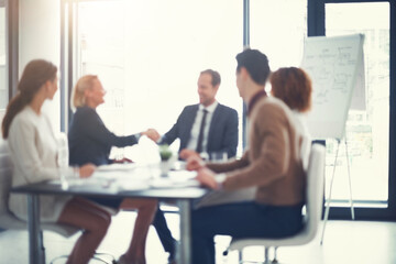 Office, blur and business people with handshake for success, sales partnership and b2b agreement....