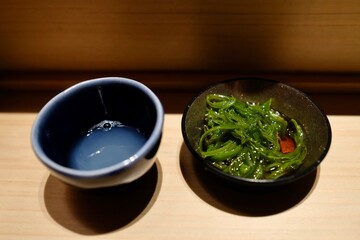 A small ceramic bowl of clam soup (ushio-jiru), served with iwa mozoku (rock mozoku) seaweed from Ishigaki, Okinawa as part of an omakase lunch at Manten Sushi Marunouchi near Tokyo Station