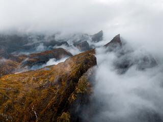 Misty Mountain Peaks Gracefully Surrounded by Soft, Ethereal Clouds in the Sky Above