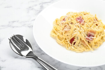 Delicious pasta Carbonara with bacon served on white marble table, closeup