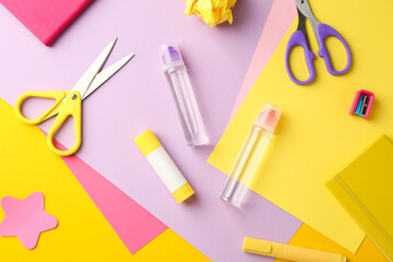 Flat lay composition with glue, scissors and other stationery on color background