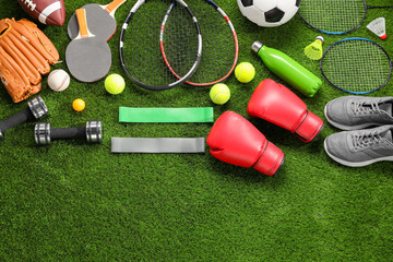 Different sport equipment on artificial grass, flat lay. Space for text