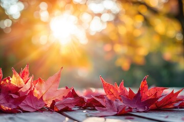 Fototapeta premium Vibrant Red Autumn Maple Leaves on Rustic Wooden Table with Golden Sunset Light, Ideal for Fall, Thanksgiving, or Nature Themes