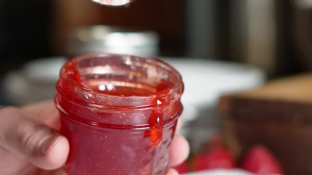 Cooking strawberry jam and canning them for food storage and for gifts.  strawberry jam made with fresh strawberries and sugar and easy recipe.