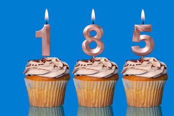 Birthday Cupcakes With Candles Lit Forming The Number 185.