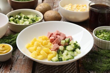 Different ingredients for okroshka soup on wooden table, closeup