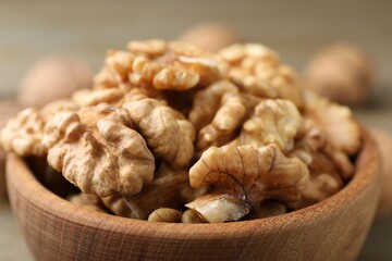 Peeled walnuts in bowl on table, closeup