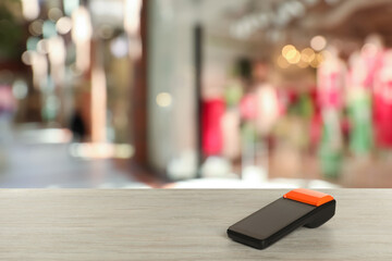 Payment terminal on wooden counter in mall