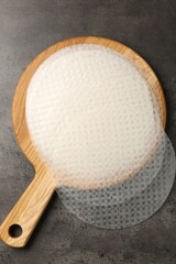 Edible rice paper sheets on grey textured table, top view