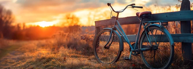 Fototapete Rund A vintage bicycle parked near a rustic wooden fence, with a sunset in the background © ABC IMAGE