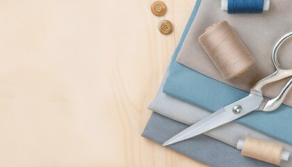 Fabric, thread, buttons, and scissors arranged on a wooden surface.