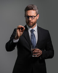 Man with headache on isolated gray studio background. Man feel pain rubbing dry eyes fatigued from work. Man taking a medicine pill from headache migraine.