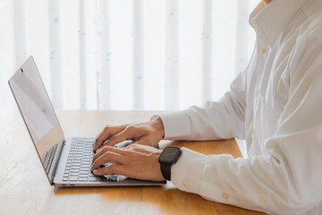 ノートパソコンで作業をする男性の手元