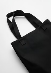 Black tote bag with thick straps on white background.