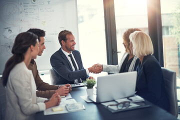 Business people, laptop and shaking hands in office for deal, sales agreement and corporate collaboration. Investors, tech and handshake in agency for new partnership, opportunity and team commitment