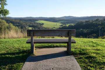 Serene Valley Vista: A Wooden Bench Overlooking Rolling Hills