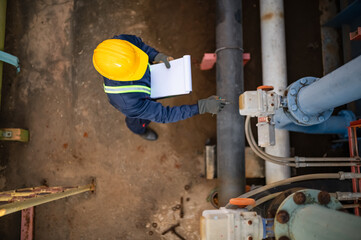 top view of a plumbing maintenance technician is inspecting the water pump system and pumping...